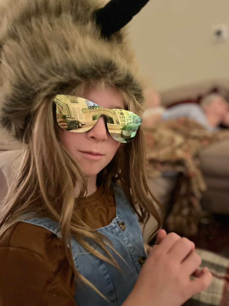 Girl at home in a furry hat and mirrored sunglasses