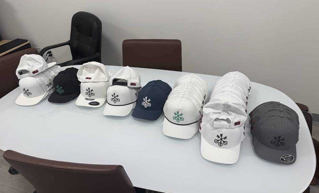 A group of custom embroidered hats arranged for a client
